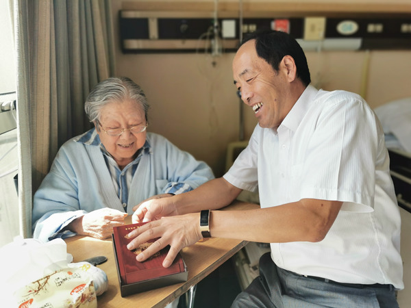 离退休支部书记黄建昌去医院看望住院的离退休老同志，并送去70周年纪念章和学习材料