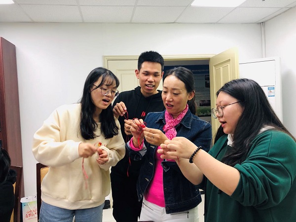 管理学院党总支书记伊铭与同学们一起制作中国结 管理学院党总支书记伊铭与同学们一起制作中国结