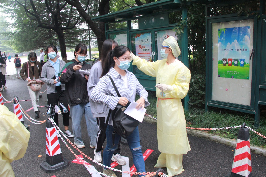 图为工作人员在为考生测量体温