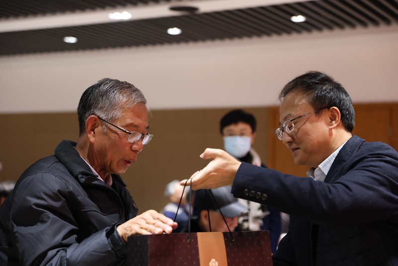 图为沈大明向离退休教职工发放新年慰问品