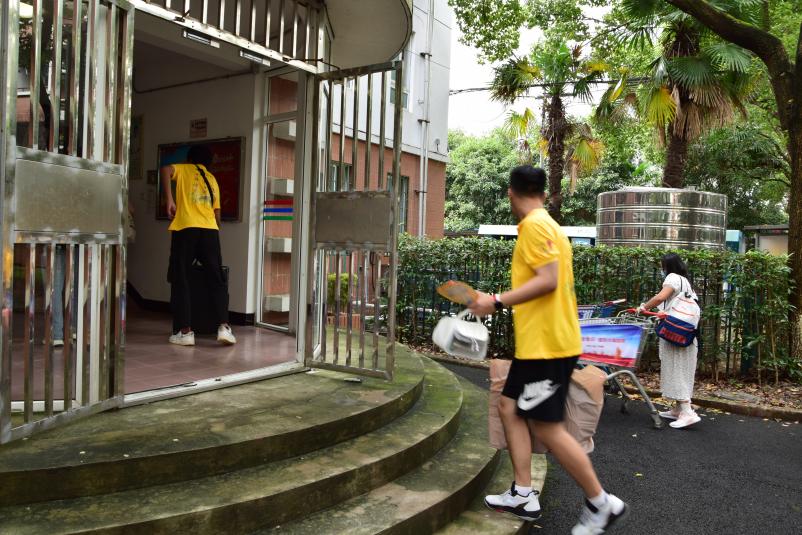 图为志愿者帮助新生搬运行李 图为志愿者帮助新生搬运行李
