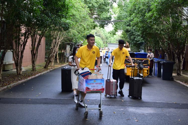 图为志愿者帮助新生搬运行李 图为志愿者帮助新生搬运行李