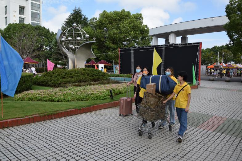 图为志愿者在校园门口迎接新生 图为志愿者在校园门口迎接新生