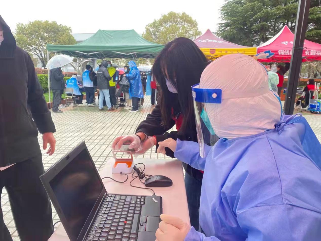 图为工商管理学院党员志愿者协助医护人员进行校园核酸检测