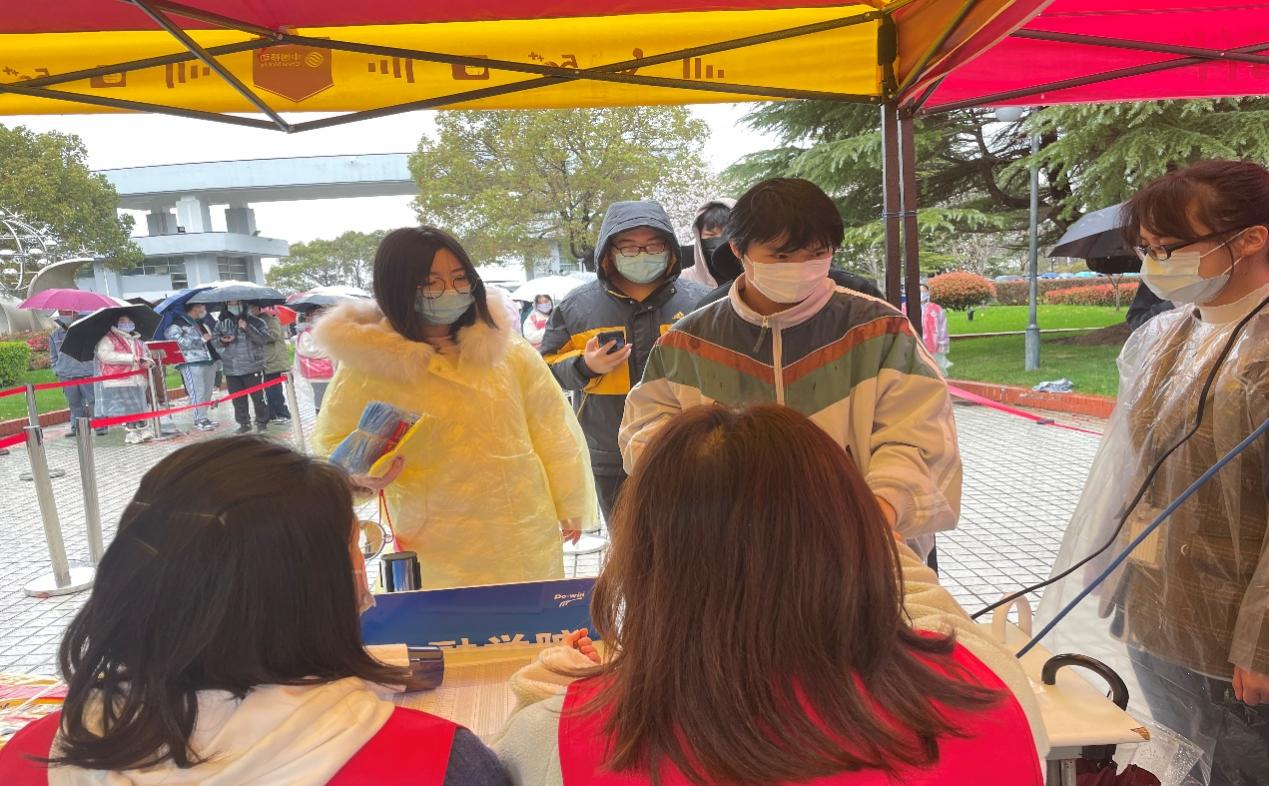 图为辅导员邵子轩、王敬玲辅助登记