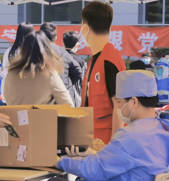 图为志愿者在核酸检测现场