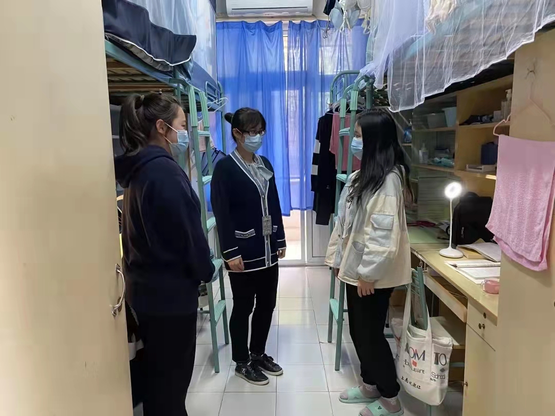 图为一线辅导员王敬玲问候在校学生