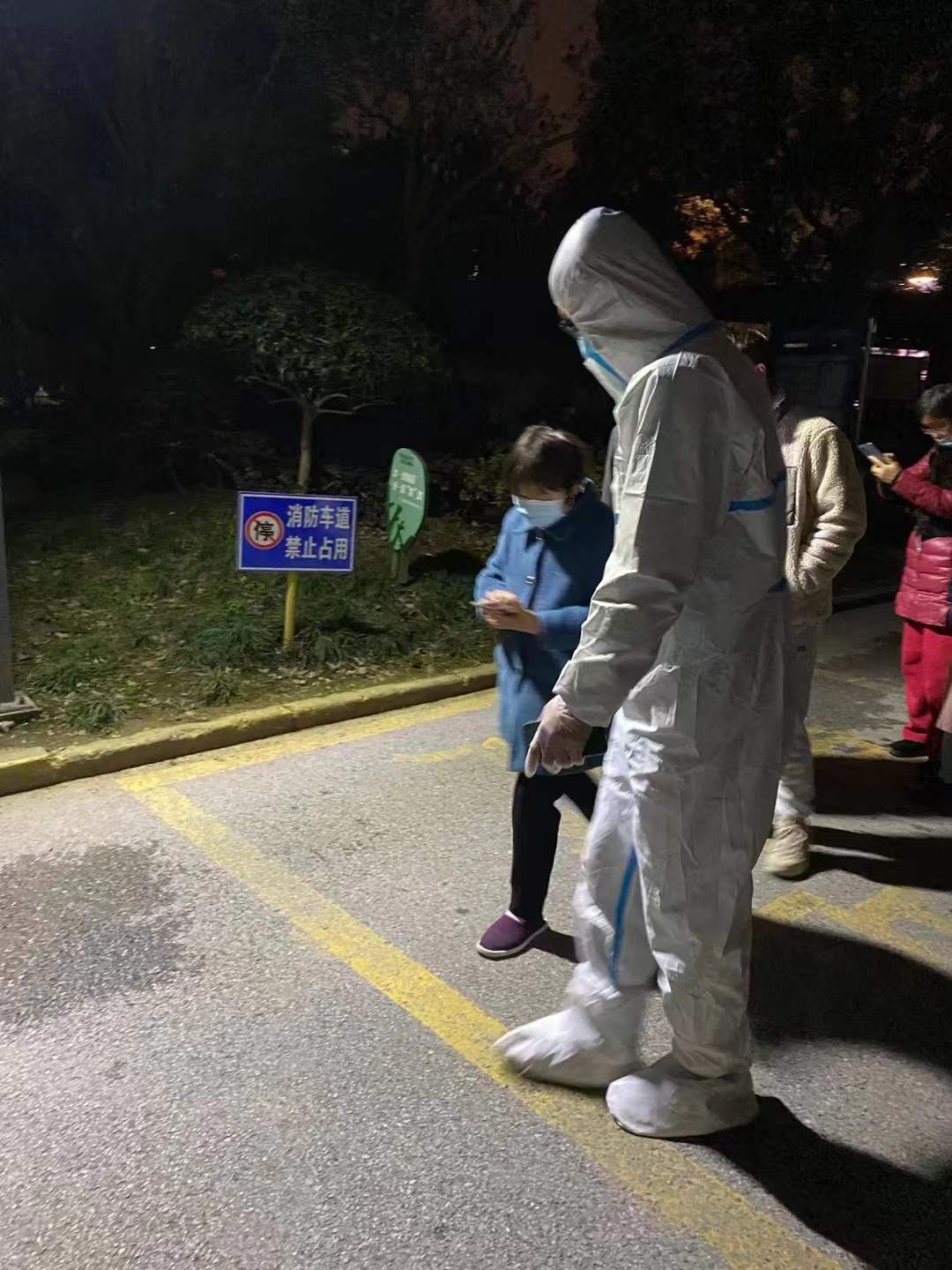 图为市场营销182班李杰引导社区居民做核酸检测