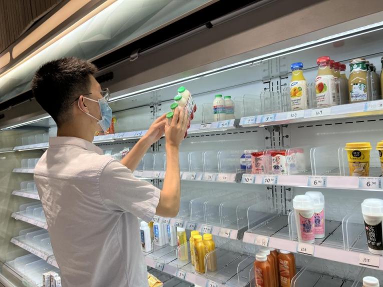 图为志愿者为云拿无人店补货