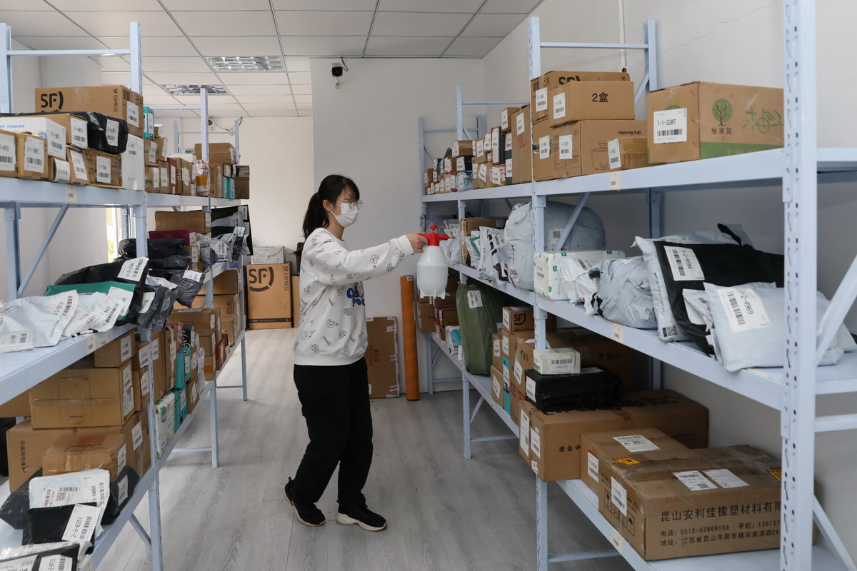 图为快递站负责人市场营销191班的郭洋洋同学正在用消毒液喷洒快递货架