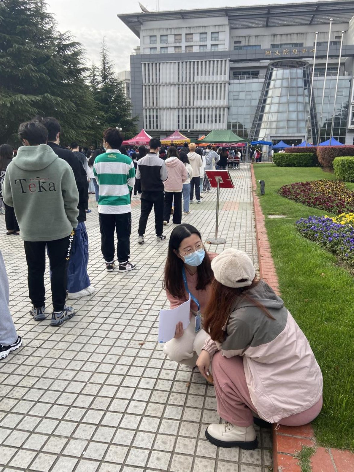 王宇佳老师在校园核酸检测现场与学生交谈