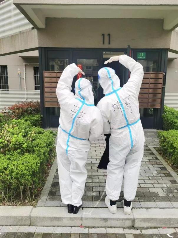 商务经济学院教职工第二党支部刘玉飞与同为党员的丈夫在小区参与志愿服务