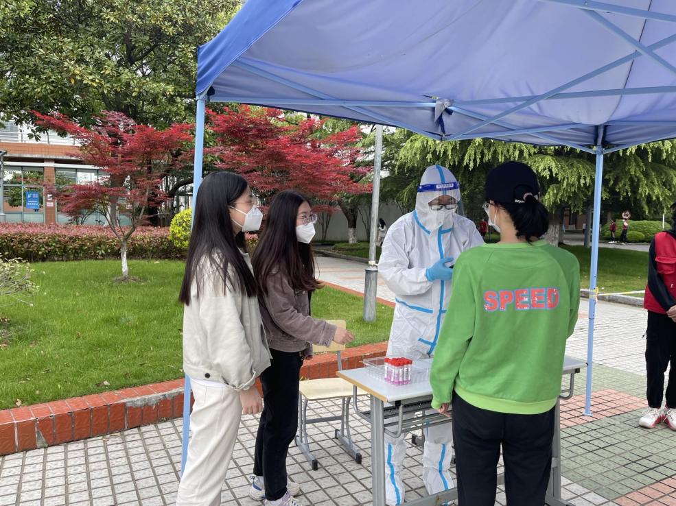 商务经济学院专职辅导员张宝颖和施甄钰指导学生进行核酸检测