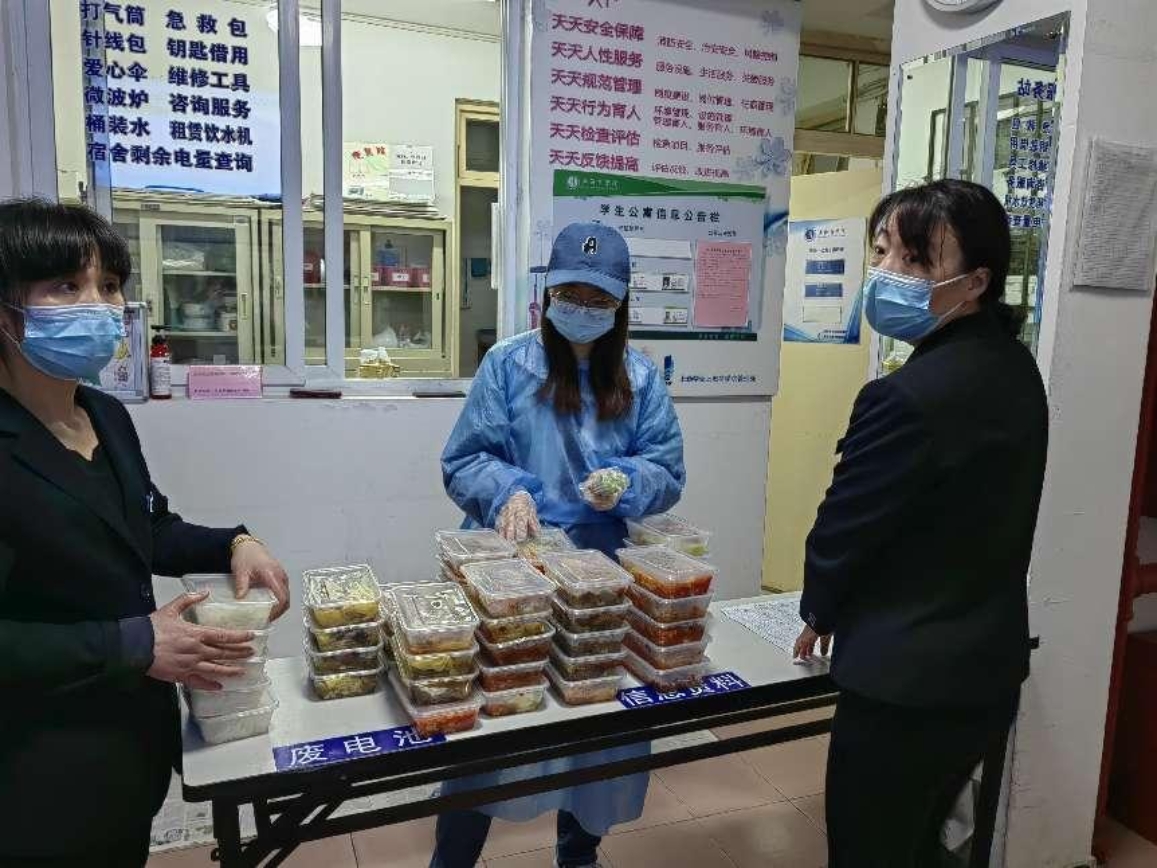 图为张子君给学生送餐