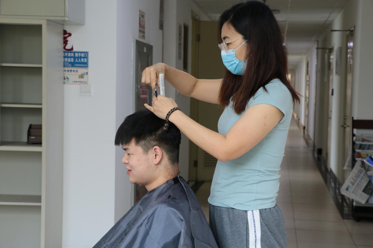 图为焦玥老师为同学们理发