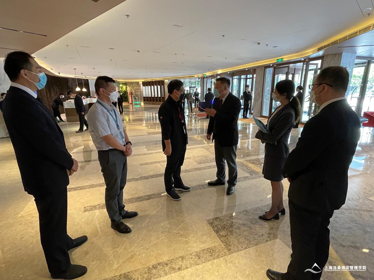 图为学院院长任建标与华夏宾馆总经理交谈