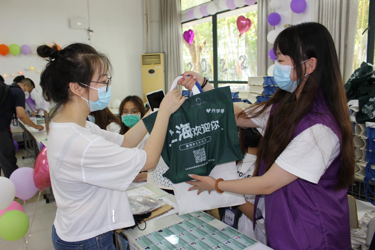 图为迎新学长帮助新生办理入学手续 图为迎新学长帮助新生办理入学手续