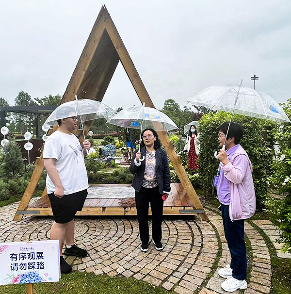 图为学生代表和企业负责人向校党委副书记、副校长劳晓芸介绍我校作品营建情况