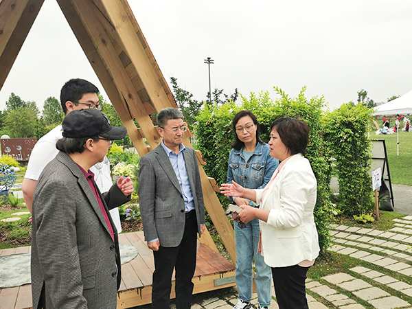 图为艺术设计学院党总支书记朱永莉向陈剑峰副校长介绍本次大学生花园节开展情况