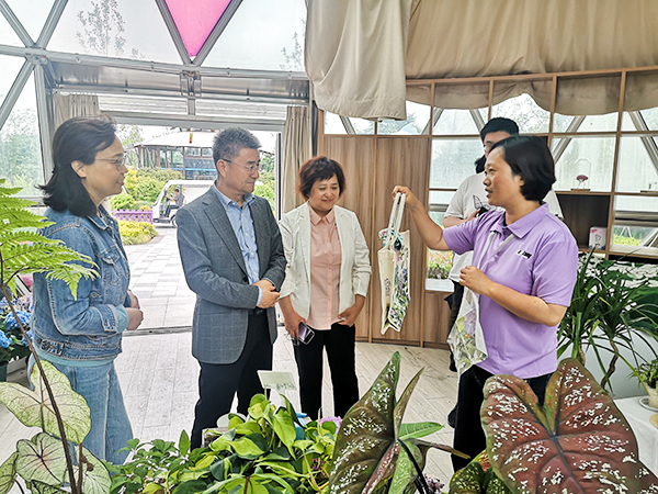 图为工作人员向陈剑峰副校长介绍我校教师设计的文创产品