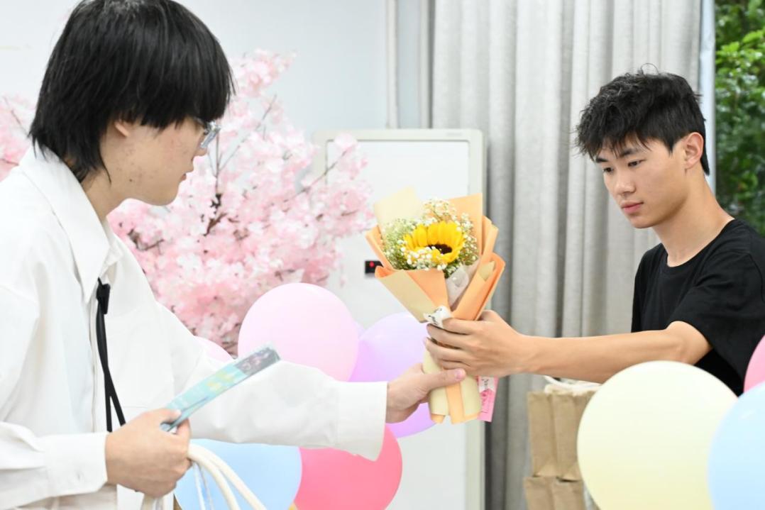 图为工作人员向毕业生分发礼物