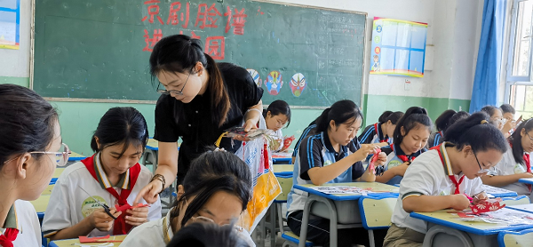 图为许丽明老师在指导孩子剪纸