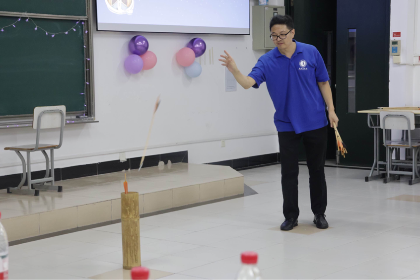 图为教师参与投壶游戏 图为教师参与投壶游戏