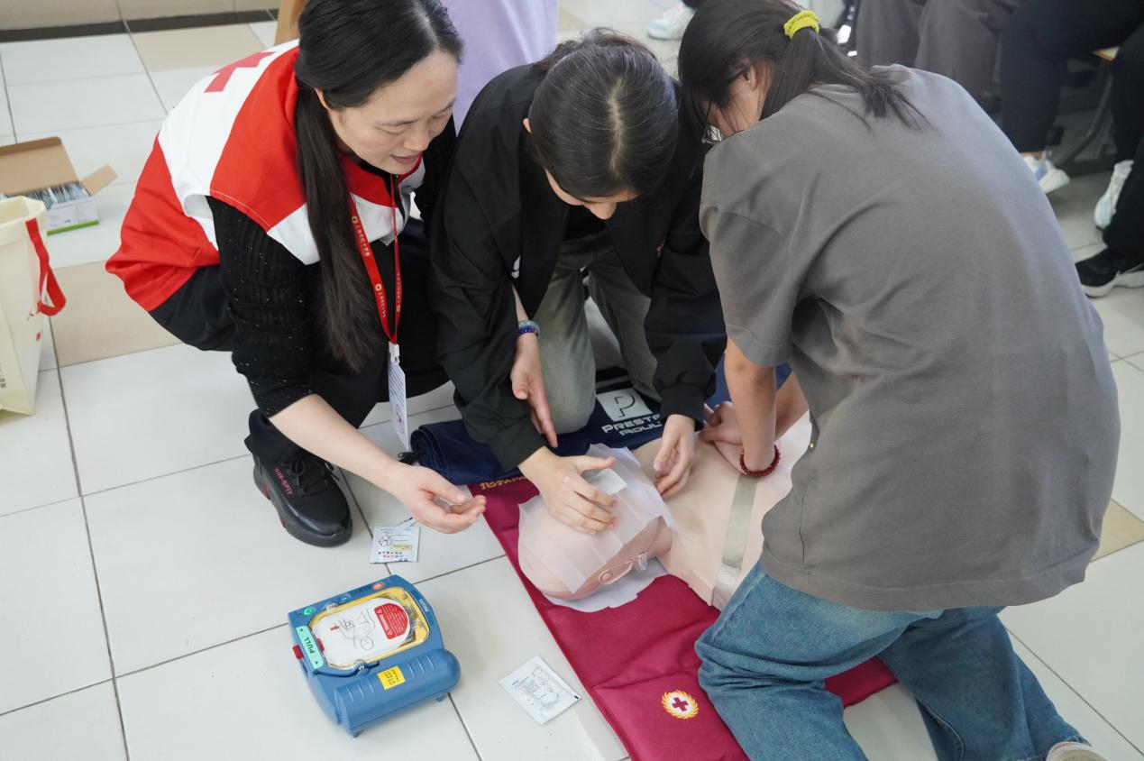 图为老师指导学员进行AED使用练习